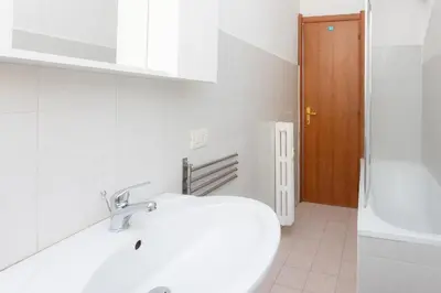 a white bathroom with a sink and a tub at Jenner Apartment by Rental in Rome in Rome