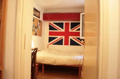 a small room with a bed with a flag on the wall at Baccina cozy apartment in Rome