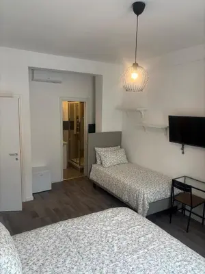a living room with two beds and a tv at PORTA FURBA Suites in Rome