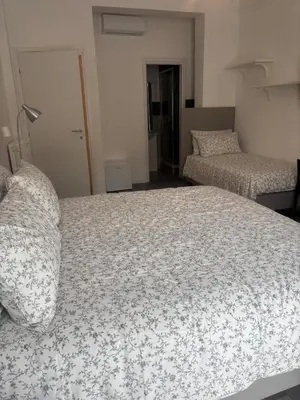 a bedroom with a bed and two beds sidx sidx sidx sidx at PORTA FURBA Suites in Rome