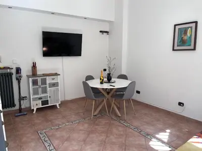a dining room with a table and a tv on a wall at Holiday home Roma Night and Day in Rome