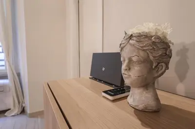 a statue of a head on a desk with a laptop at Beautiful Apartment in the Heart of Rome in Rome