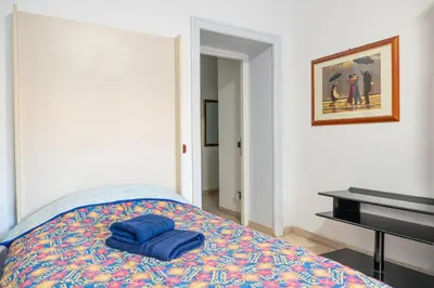 a bedroom with a bed with two blue towels on it at Lion Renting Marconi in Rome