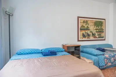 a bedroom with a bed and a blue couch at Lion Renting Marconi in Rome