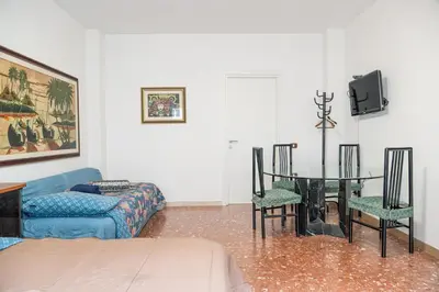 a living room with a couch and a table and chairs at Lion Renting Marconi in Rome
