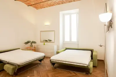 two beds in a room with a window at La porta Magica, la casa tra le basiliche in Rome