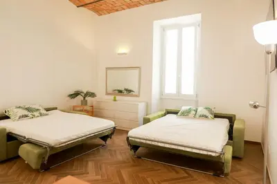 a room with two beds and a window at La porta Magica, la casa tra le basiliche in Rome