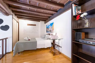 a bedroom with a bed and a table in a room at Loft Trastevere 2 floors in Rome