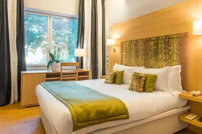 a hotel room with a bed and a desk and a window at Chic&Town Luxury Rooms Piazza del Popolo in Rome