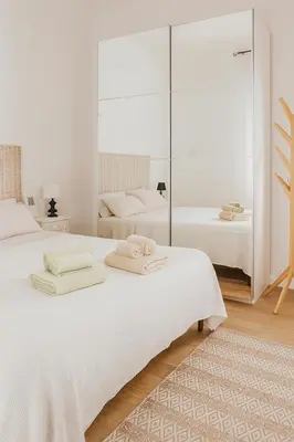 a white bedroom with two beds and a mirror at Casetta Beatrice Cozy Flat near Vatican in Rome