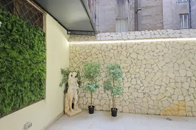 a teddy bear and two potted plants on a wall at Principe Amedeo piano terra in Rome