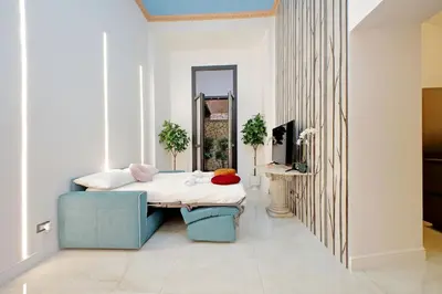 a room with a bed and a blue chair at Principe Amedeo piano terra in Rome