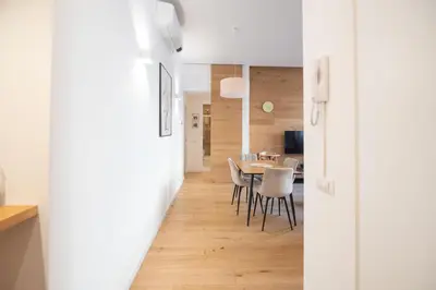 a kitchen and dining room with white walls and a table and chairs at Barbra Suite Testaccio in Rome