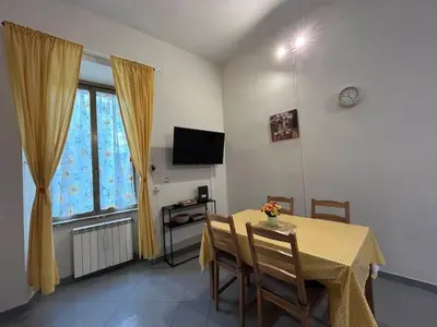 a dining room with a table and chairs and a television at A Casa di Mario al Pigneto in Rome