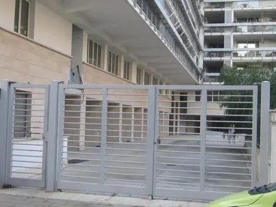 a metal gate in front of a building at Porta Portese Trastevere Bright New Apartment in Rome