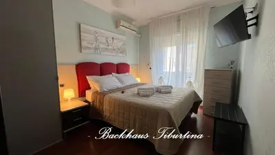 a bedroom with a bed with a red headboard at Backhaus Tiburtina in Rome