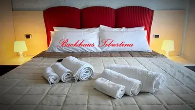 a bedroom with a large bed with towels on it at Backhaus Tiburtina in Rome