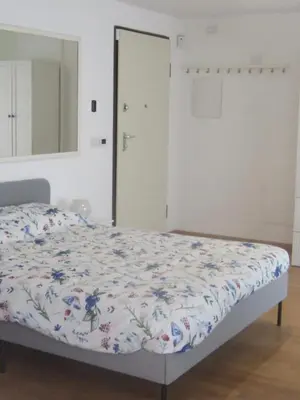 a bedroom with a bed with a floral comforter at Penthouse in Trastevere - Entire House in Rome