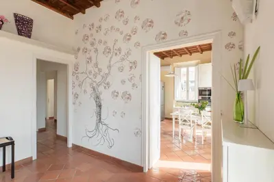 a living room with a wall mural of a tree at iFlat Trevi Charm, Elegant & Comfy Roman Escape in Rome