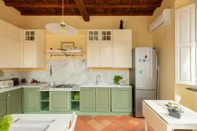 a kitchen with green cabinets and a white refrigerator at iFlat Trevi Charm, Elegant & Comfy Roman Escape in Rome