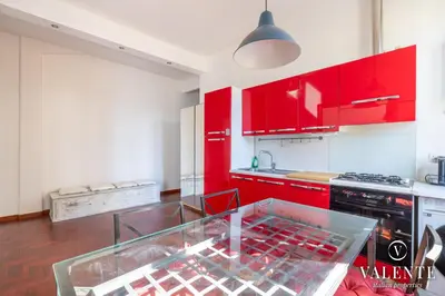 a kitchen with red cabinets and a glass table at Comfy and Elegant Apartment in Rome