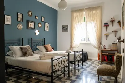 a bedroom with two beds and a chair at Casa Nanna Chic in Vatican in Rome