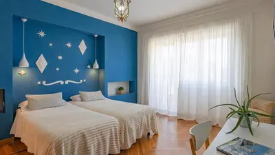 two beds in a room with blue walls at Vatican Park Residence in Rome