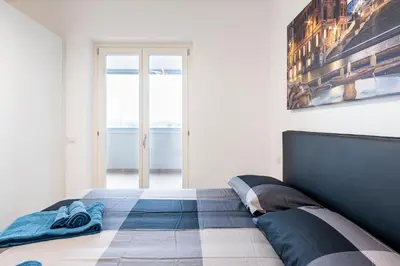a bedroom with a bed and a painting on the wall at Brand new apartment with private parking space in Rome