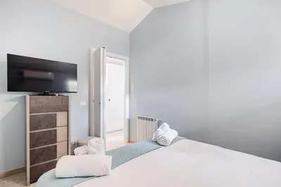 a bedroom with a bed with a flat screen tv at Blue Sky Apartment - 5 min Vatican in Rome