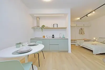 a kitchen and a living room with a table and a kitchen at Charm Apartment San Giovanni in Rome