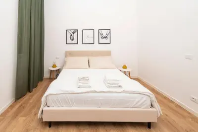 a bedroom with a white bed with two tables at Casa Gazometro in Rome
