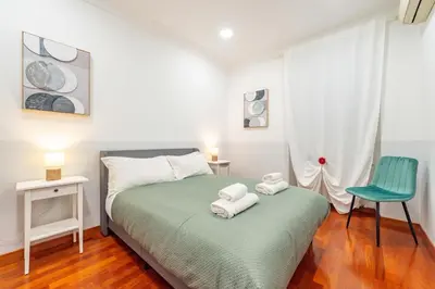 a bedroom with a bed and a blue chair at Domus 44 Apartment in Rome