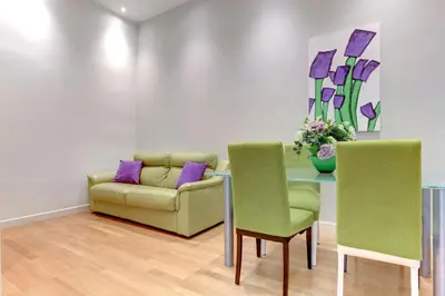 a living room with a couch and a table with chairs at Porta Pia Suite in Rome