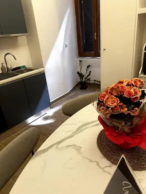 a bouquet of roses on a table in a kitchen at The Apartment 56 in Rome