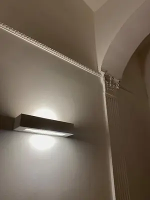 a light on a wall in a room at The Apartment 56 in Rome