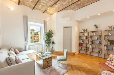 a living room with a couch and a book shelf at Dandolo Top Floor Trastevere in Rome