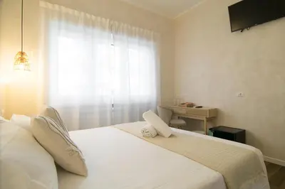 a bedroom with a large white bed with a window at Lilla Eco House - Vaticano in Rome