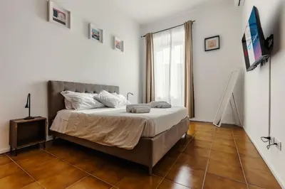 a bedroom with a large bed and a window at Domus Merulana 209 Colosseum Apt in Rome