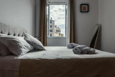 a bed with towels on it with a window at Domus Merulana 209 Colosseum Apt in Rome
