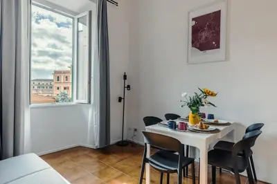 a dining room with a table and chairs and a window at Domus Merulana 209 Colosseum Apt in Rome