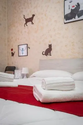 a bedroom with a bed with two black cats on the wall at Margot Appia's dream in Rome