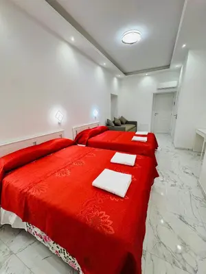 a bedroom with two red beds and a couch at Acropoli in Rome