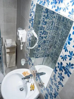 a bathroom with a sink and a shower with a mirror at De Camillis Apartments in St Peter in Rome