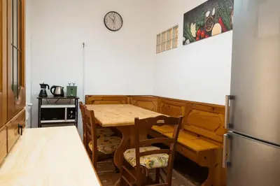 a kitchen with a table and a clock on the wall at Vatican Giuliano’s House in Rome