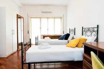 two beds in a room with white walls at Vatican Giuliano’s House in Rome