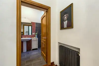 a bathroom with a portrait of a man on the wall at Rome As You Feel - Argentina Luxury Apartment in Rome