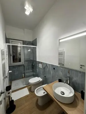 a bathroom with two toilets and a sink and a shower at Olimpia Love Apartament in Rome