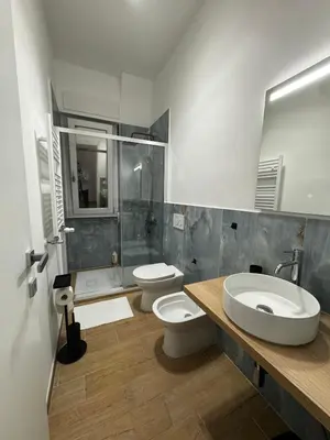 a bathroom with two toilets and a sink and a shower at Olimpia Love Apartament in Rome