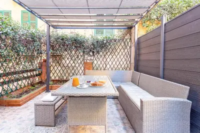 a patio with a table and wicker chairs at Casina Roxy in Rome