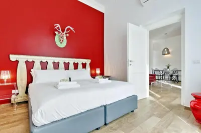 a bedroom with a red wall and a bed at Monti Apartments - My Extra Home in Rome